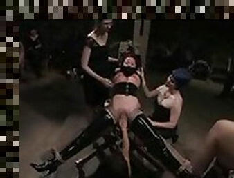 Girl in latex is displayed for an audience while tied up