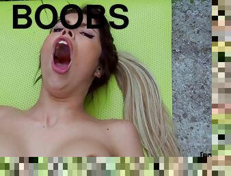 Kinky brunette with fake boobs pleasuring Jordi outdoors
