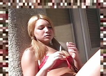 Corri sits outdoors in red lingerie and smokes