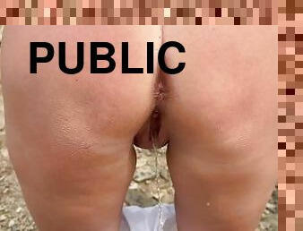 Girl walking on the road and starting pee in public