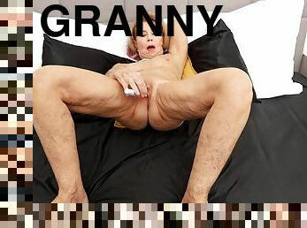 Horny blonde granny fucks herself in bed with a dildo