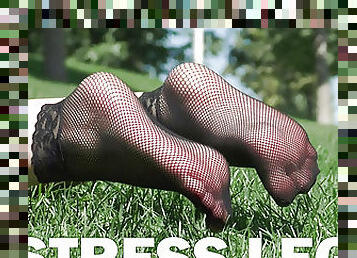 Feet in fishnets socks on the grass