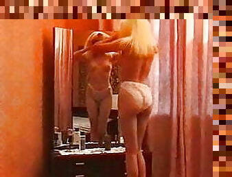 The blonde gets naked in front of the mirror for sex