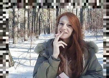 redhead smokes in the forest
