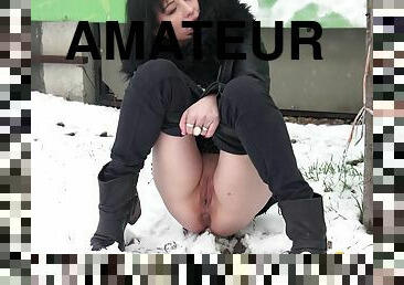 Brunette girl has got to pee in the winter snowy street