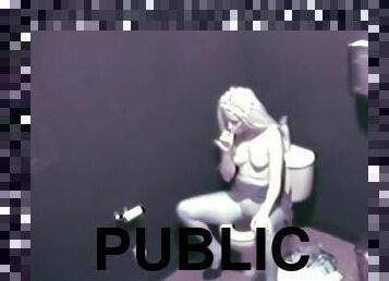Hot blonde fingers her pussy in a public restroom
