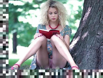 Beauty Blonde reads a book outdoor
