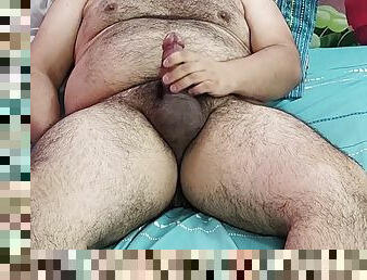 Fat man masturbates on a blue bed