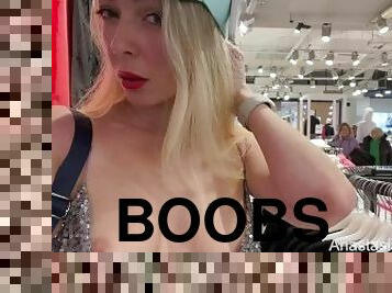 Adorable lady in a sexy dress flashes boobs in a public store.