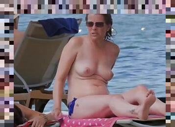 Bikini chick takes her top off to tan