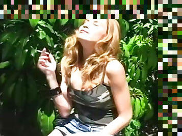 Blonde smokes while posing in outdoor